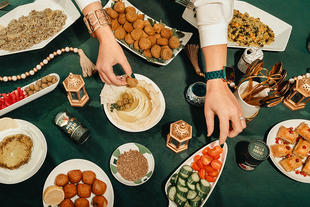 A table spread with Afia falafel, kibbeh, hummus, vegetables and spices