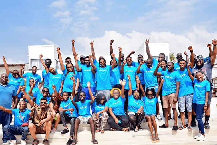 Afriex employees gathered on steps in blue company shirts