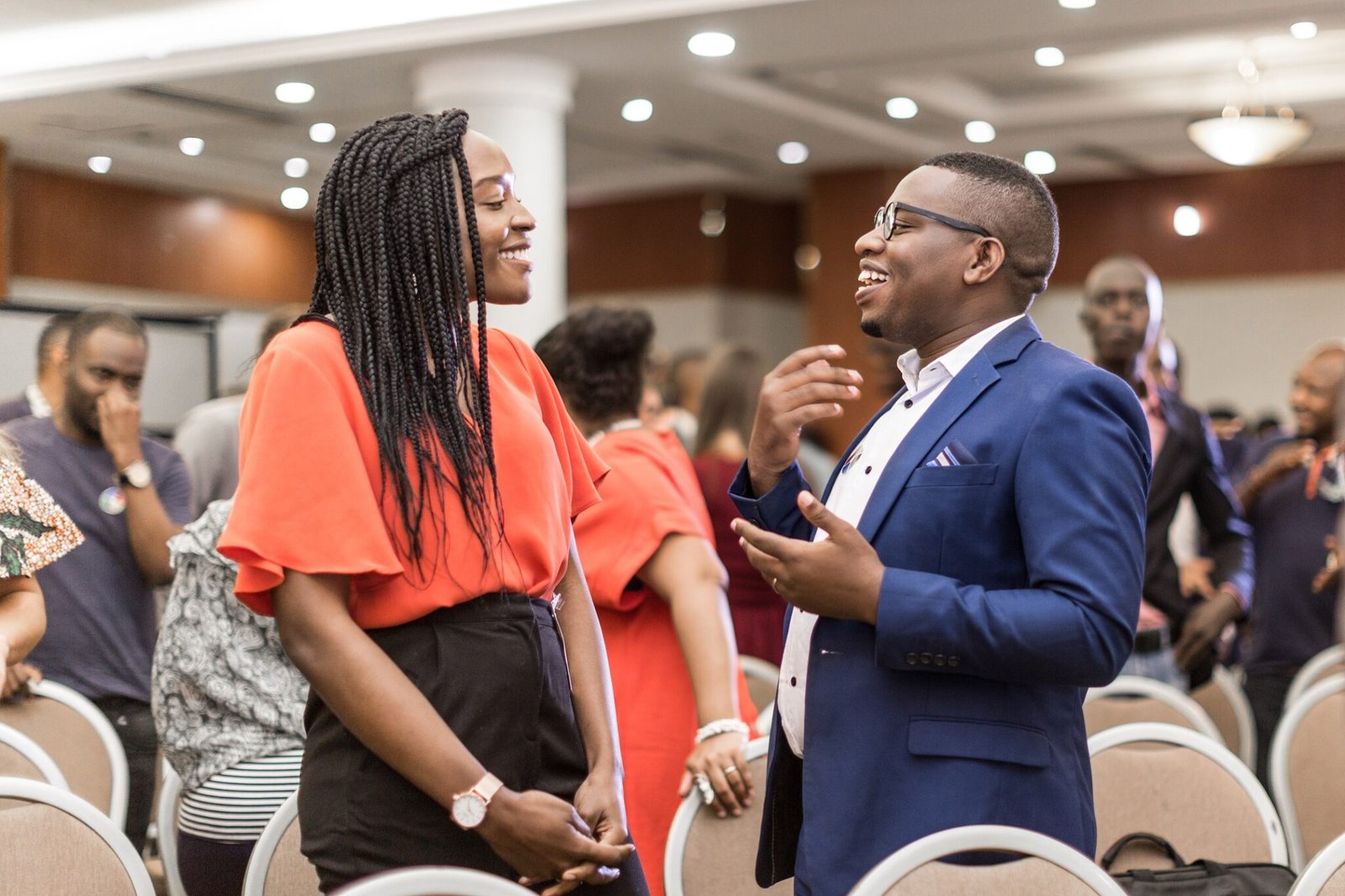 Two attendees talking and smiling between rows of chairs at an AfriLabs event