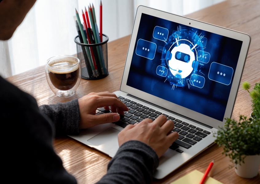 Illustrative photograph of a laptop displaying a chatbot graphic