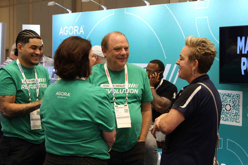 Agora team members talking with a visitor at the company’s NIADA exhibition booth
