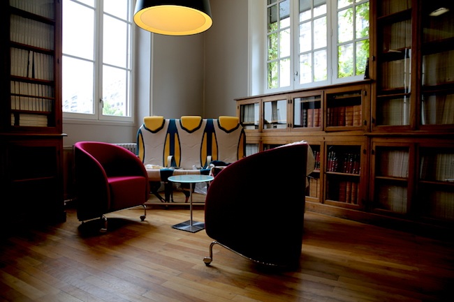 Bookshelves, tall windows and colorful chairs in Agoranov’s former library