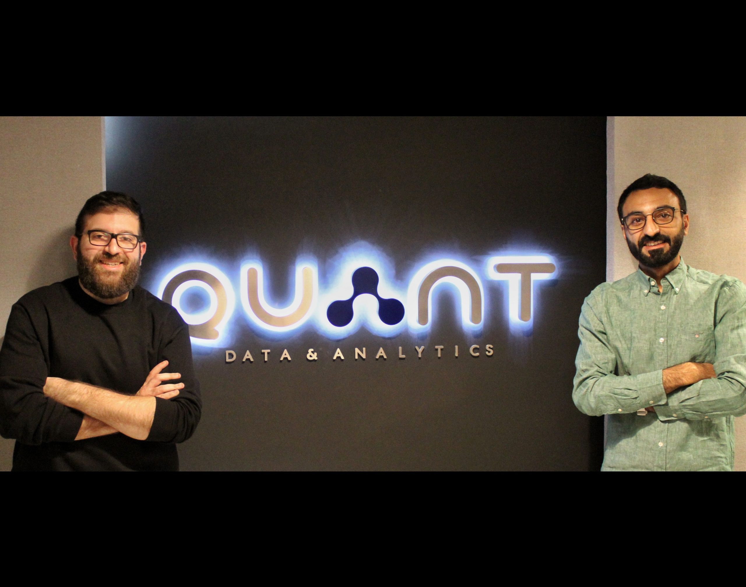 Ahmed Bukhamseen, right, with a Quant colleague beside the illuminated company sign