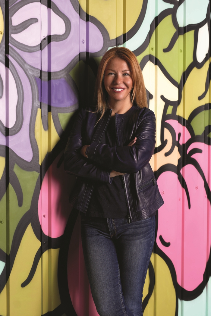 Ahu Büyükkuşoğlu Serter standing against a colourful painted wall at Fark Labs