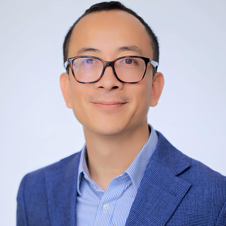 AI 2030 founder Xiaochen Zhang wearing glasses and a blue jacket