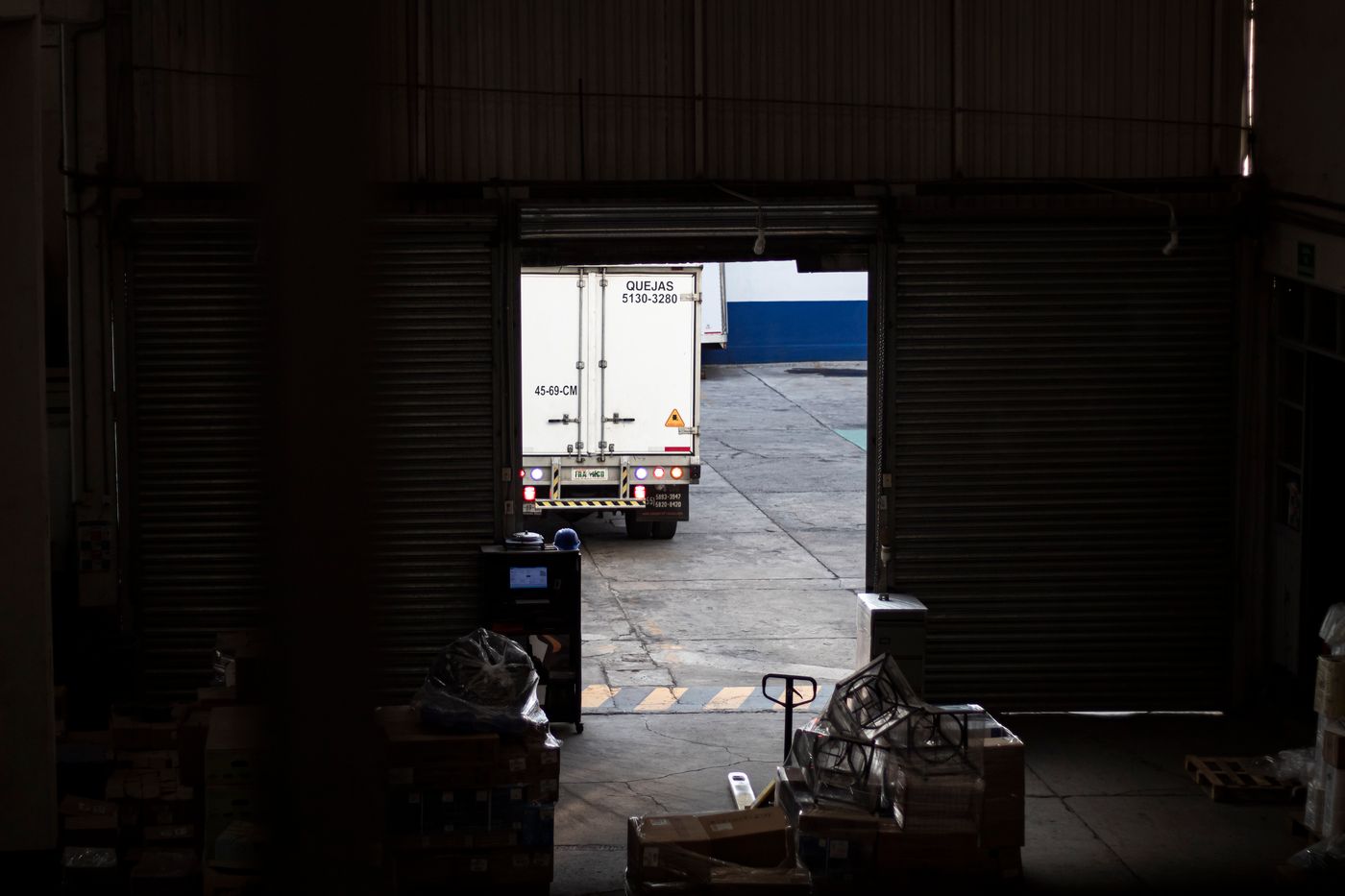Truck leaving a warehouse loading dock, viewed from inside the building