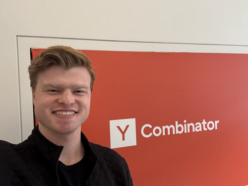 Aidan Pratt standing beside a Y Combinator sign