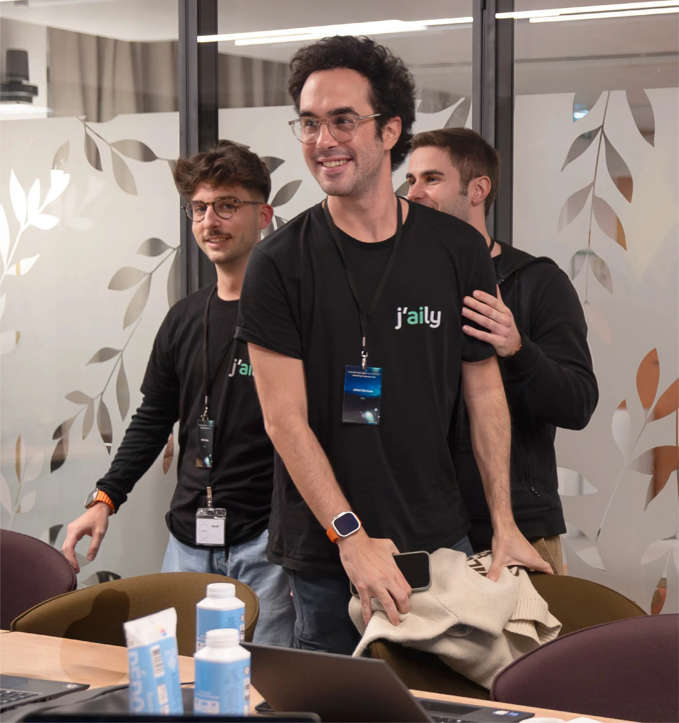 Three Aily team members wearing company shirts and conference badges