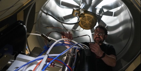 A person working on Aircapture equipment beneath a large industrial fan