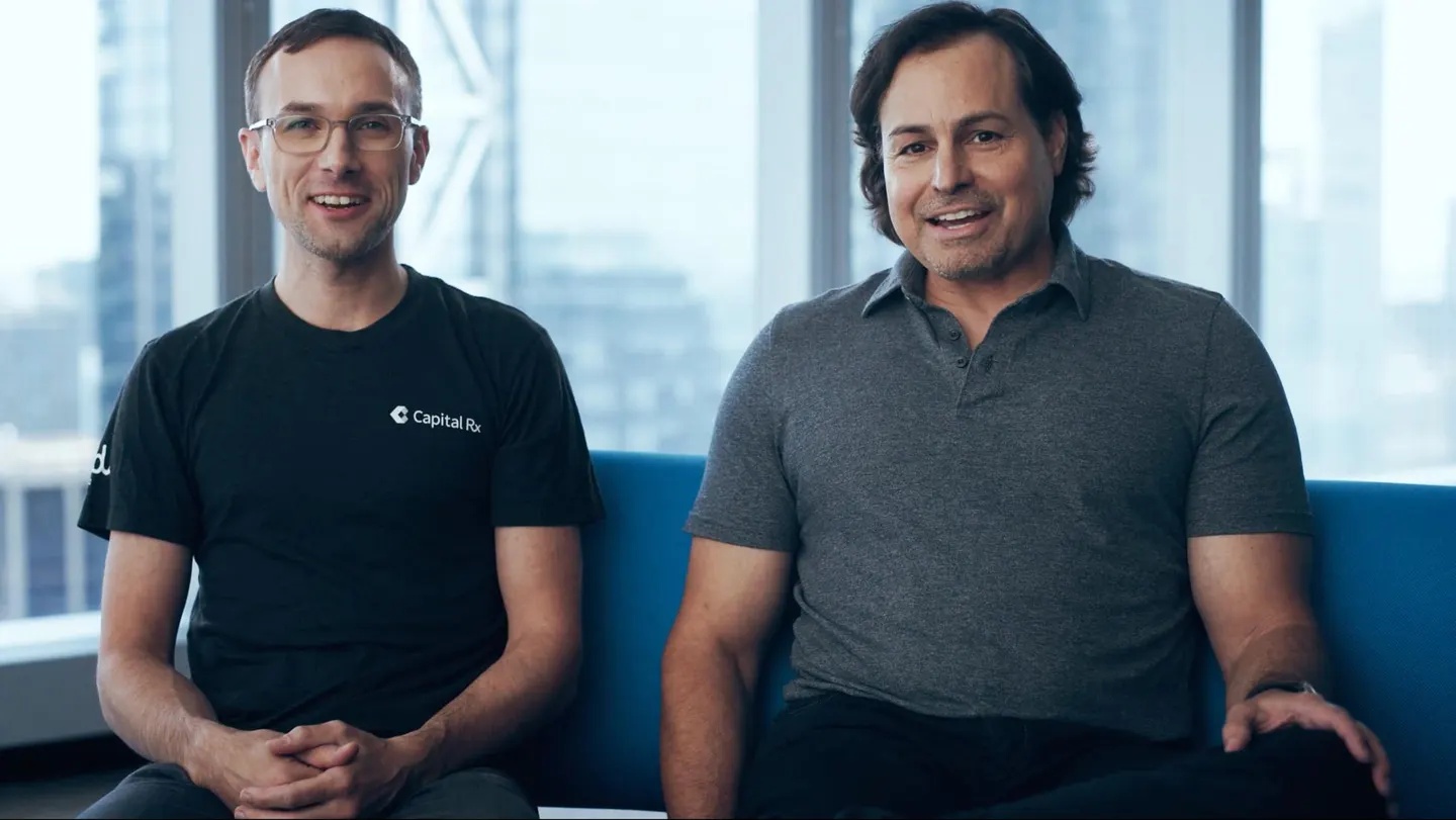 Co-founders Ryan Kelly, left, and AJ Loiacono, right, seated together on a blue sofa