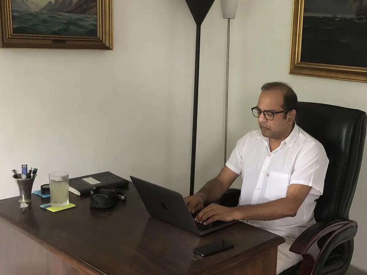 Ajay Agrawal working at a laptop in his home office