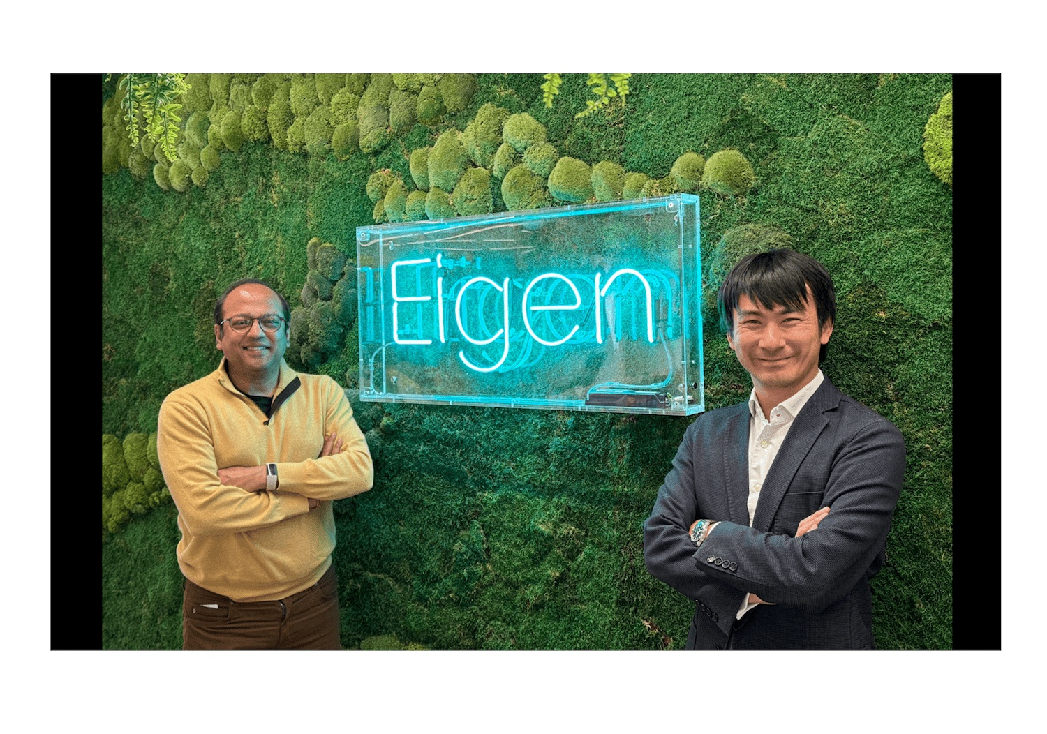 Ajay Agrawal, left, and Eigen co-founder Lewis Liu beside an Eigen sign