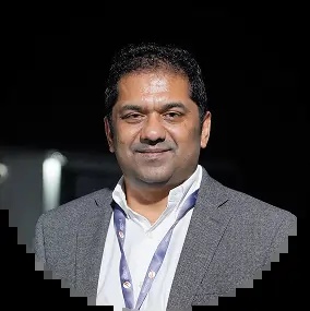 Aji Abraham wearing a gray jacket and conference lanyard, in a photograph published by CodeVentures