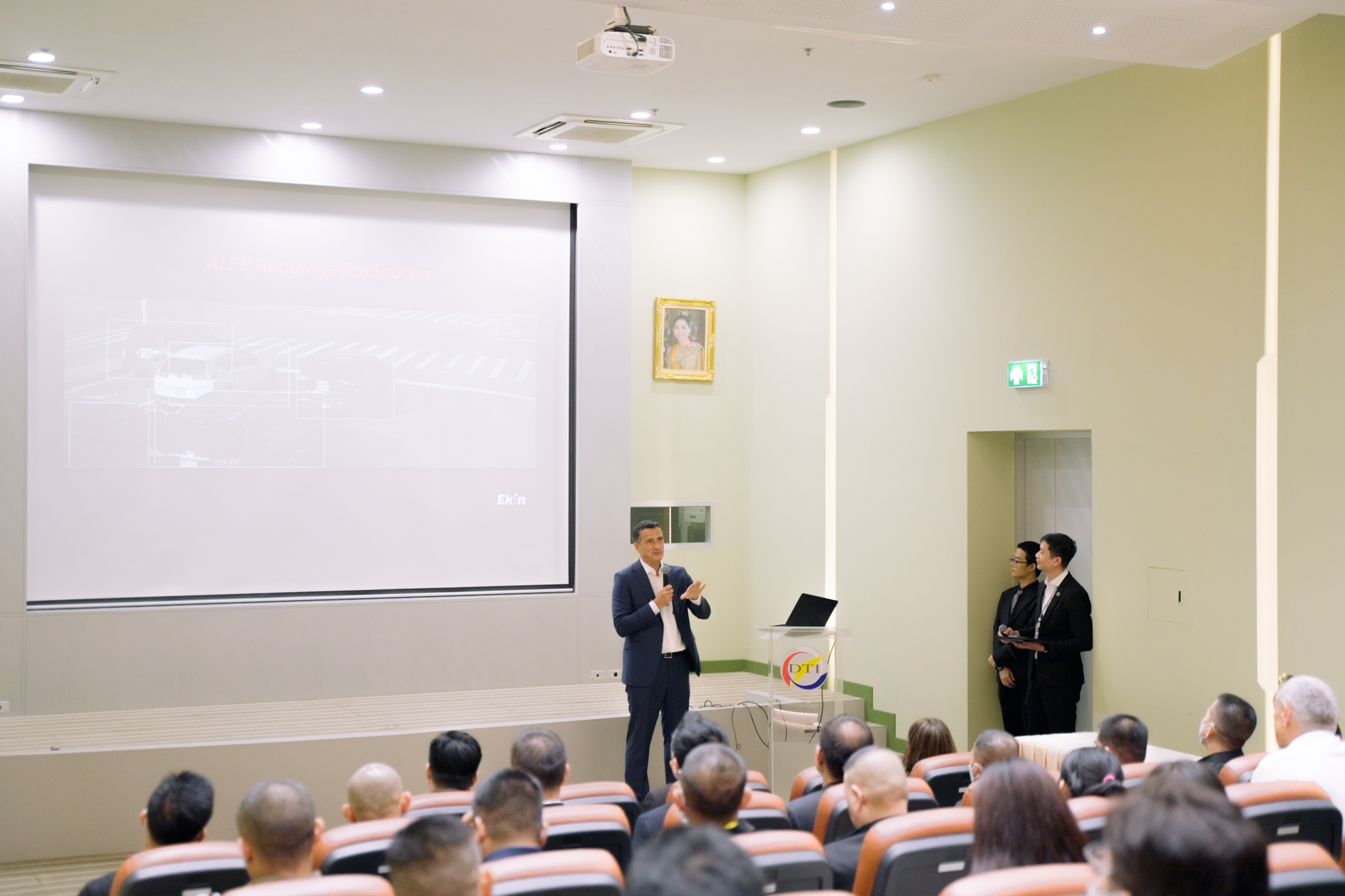 Akif Ekin speaking into a microphone before an audience at the Thailand Roadshow in Bangkok