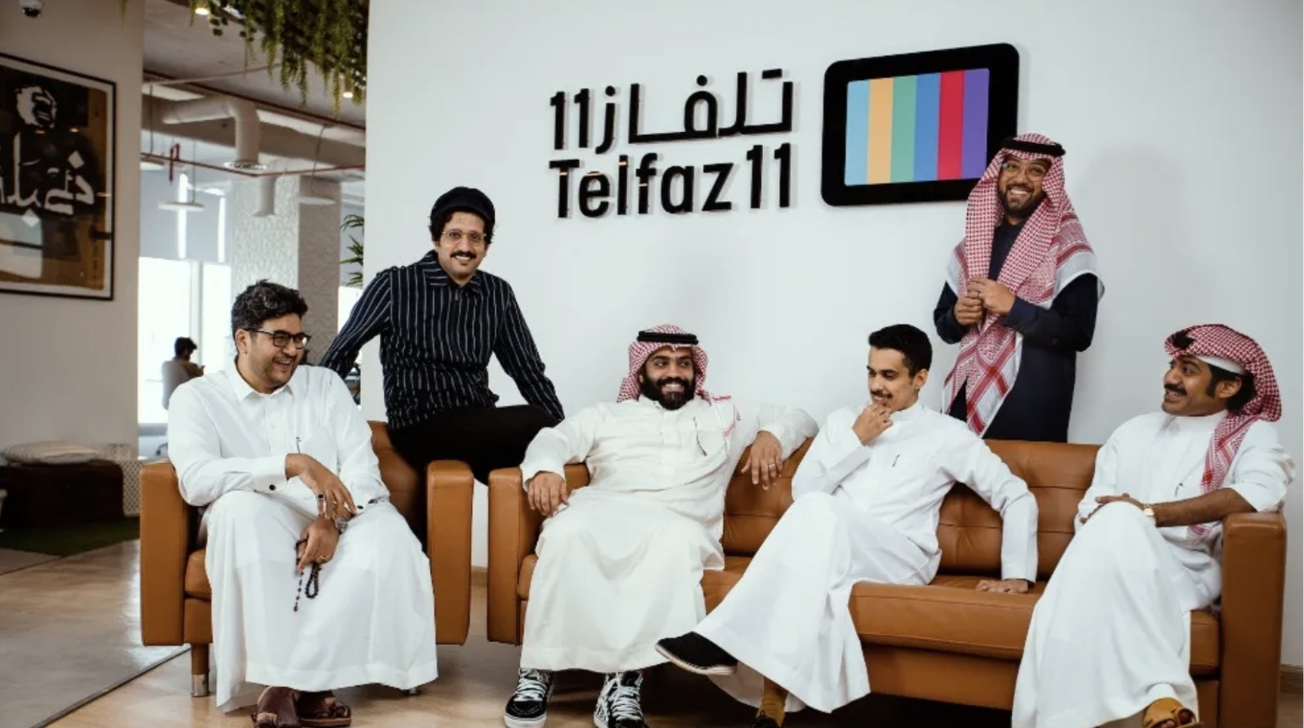 Members of the Telfaz11 team gathered around a sofa in the studio