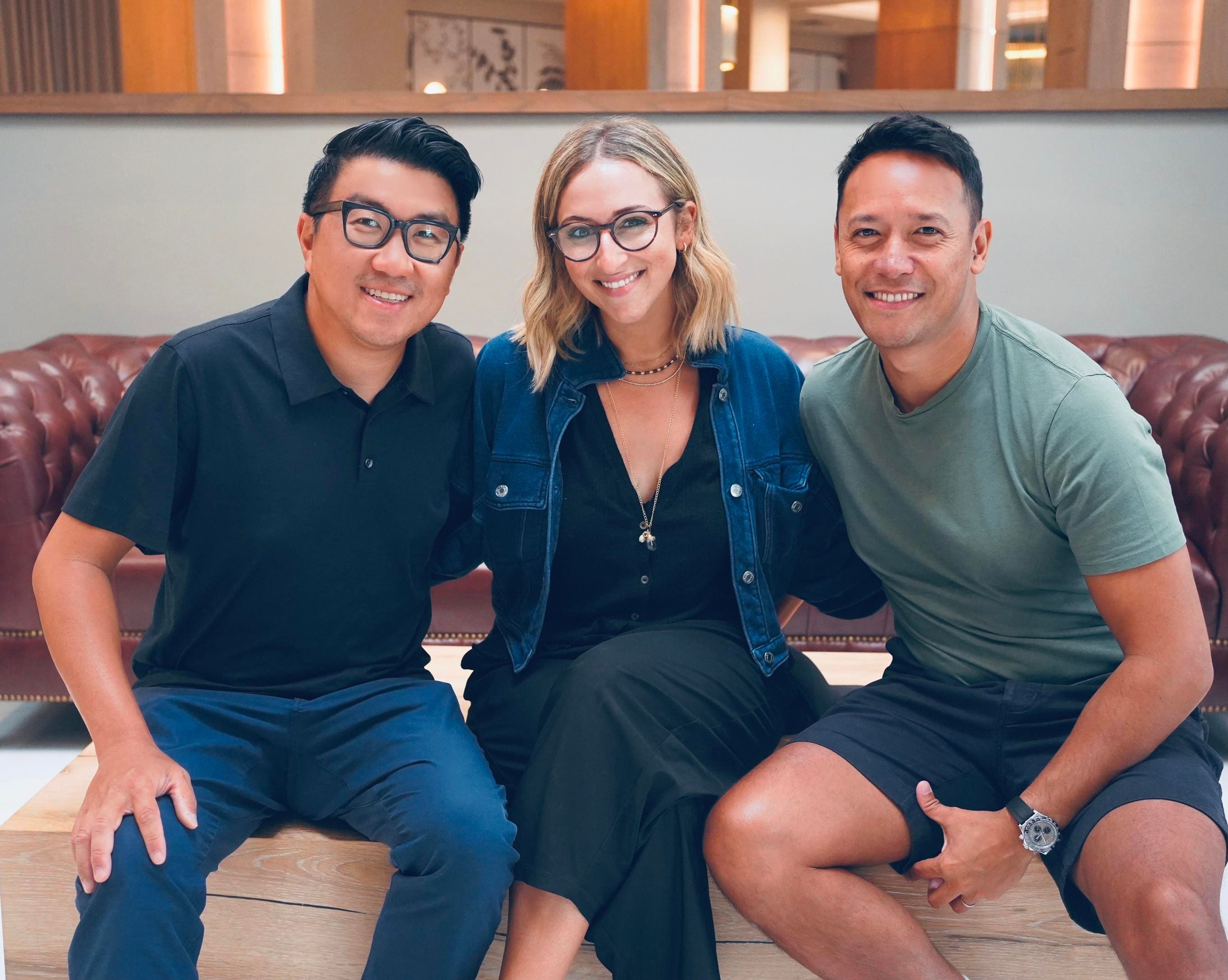 Alan Charming Chan, Emily Greenberg and Charlie Carpenter seated together on a leather couch.