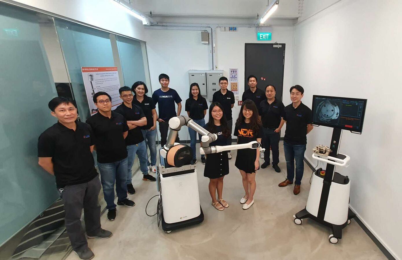 The NDR team gathered around robotics equipment in their workspace