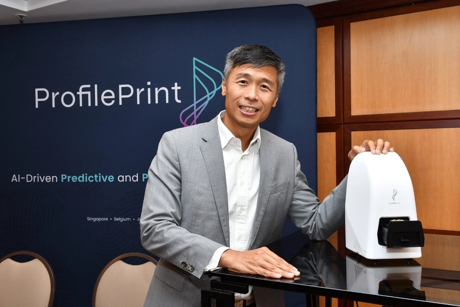 Alan Lai beside a ProfilePrint ingredient analyser