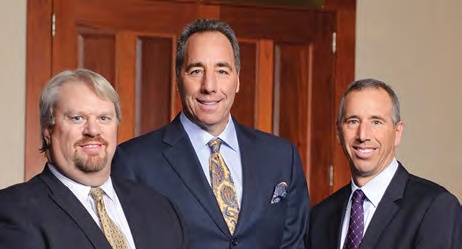GCG partners Rick Loudenback, Alan Levitz and Rick Levitz standing together in front of wooden doors