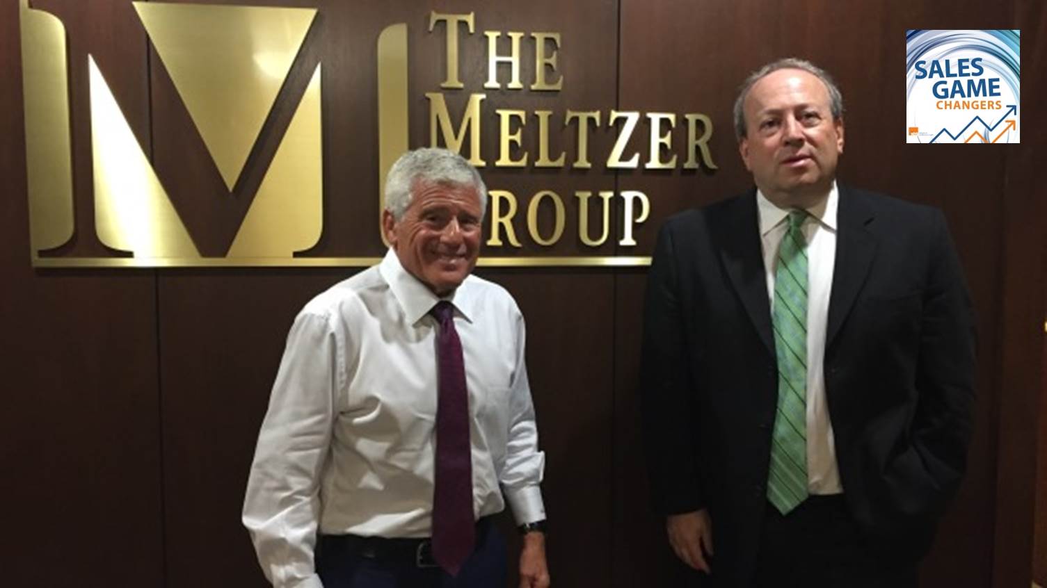 Alan Meltzer, left, with podcast host Fred Diamond in front of The Meltzer Group sign