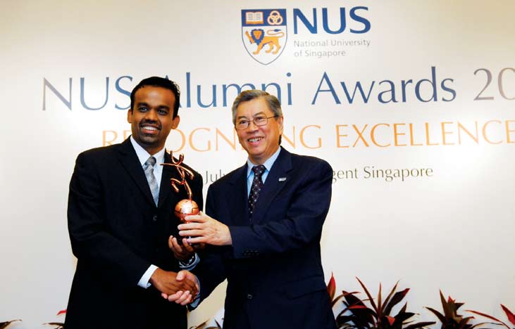 Alan Sevugan, left, receiving an alumni award from Wong Ngit Liong