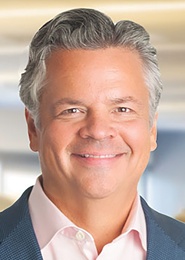 Alberto Casellas smiling in a dark jacket and pale shirt