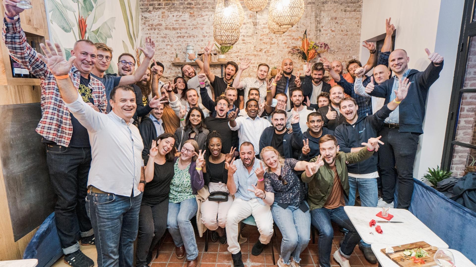 Gravitee team posing together with raised hands in a restaurant
