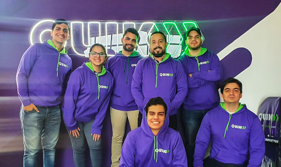 The QUIK team wearing purple company hoodies in its Maracaibo workspace