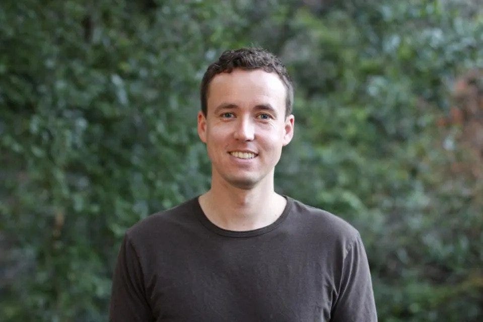 Alek Koenig outdoors in a dark T-shirt