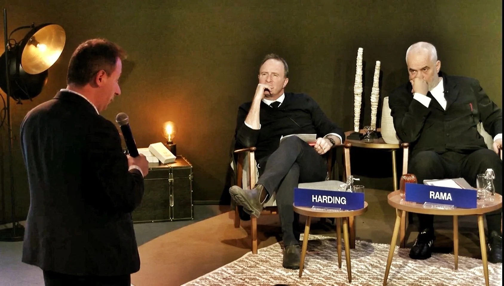Yampolskiy holding a microphone in conversation with two seated event participants