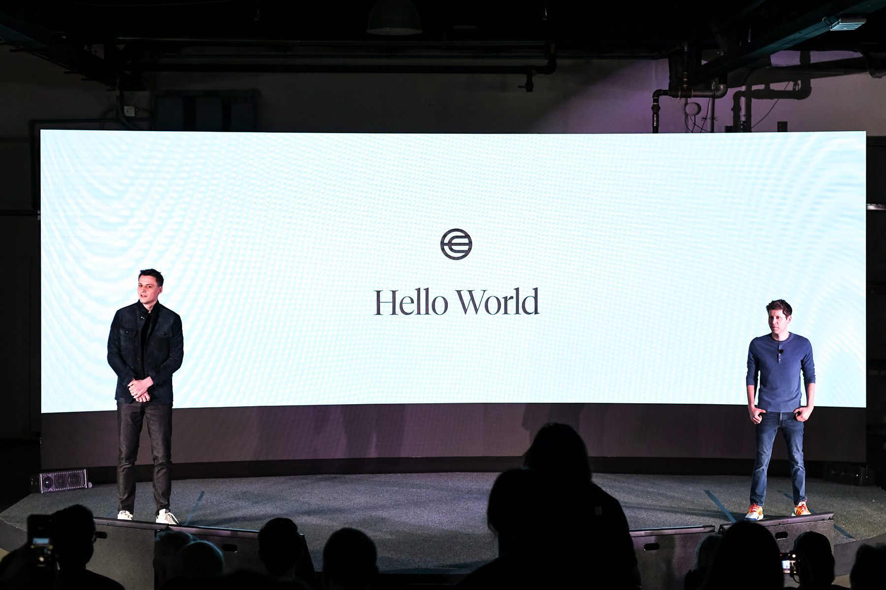 Alex Blania, left, and Sam Altman onstage beside a Hello World screen in San Francisco