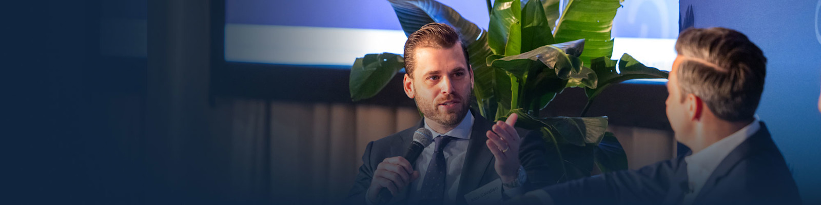 Alex Cavalieri speaking into a microphone during a CAIS conversation