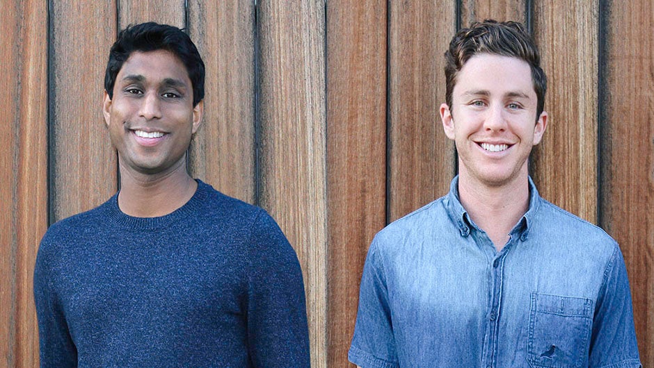 Ankur Jain on the left and Alex Fiance on the right, standing in front of a wooden wall