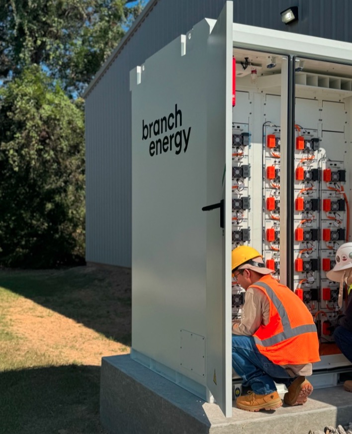 Workers in safety equipment attending to an open Branch Energy battery cabinet