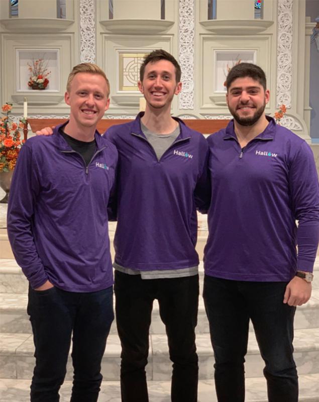 Hallow co-founders Alex Jones, Alessandro DiSanto and Erich Kerekes standing together in matching purple Hallow tops inside a church
