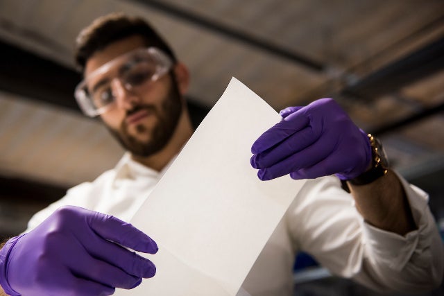 Alex Rappaport holds a sample of ZwitterCo membrane material in a work setting