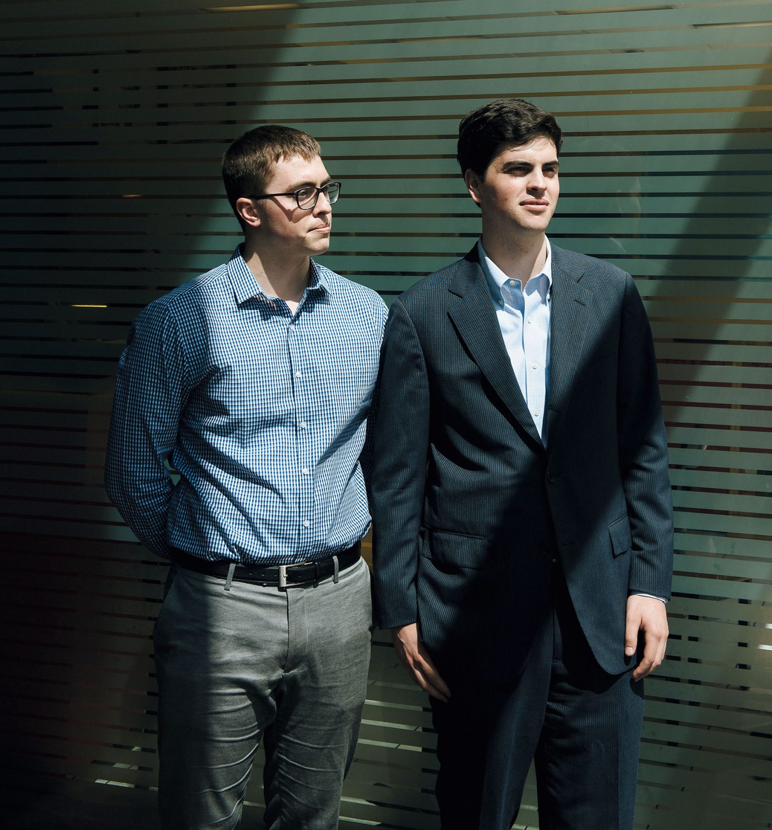 Quorum cofounders Jonathan Marks, left, and Alex Wirth, right, standing together in front of striped glass