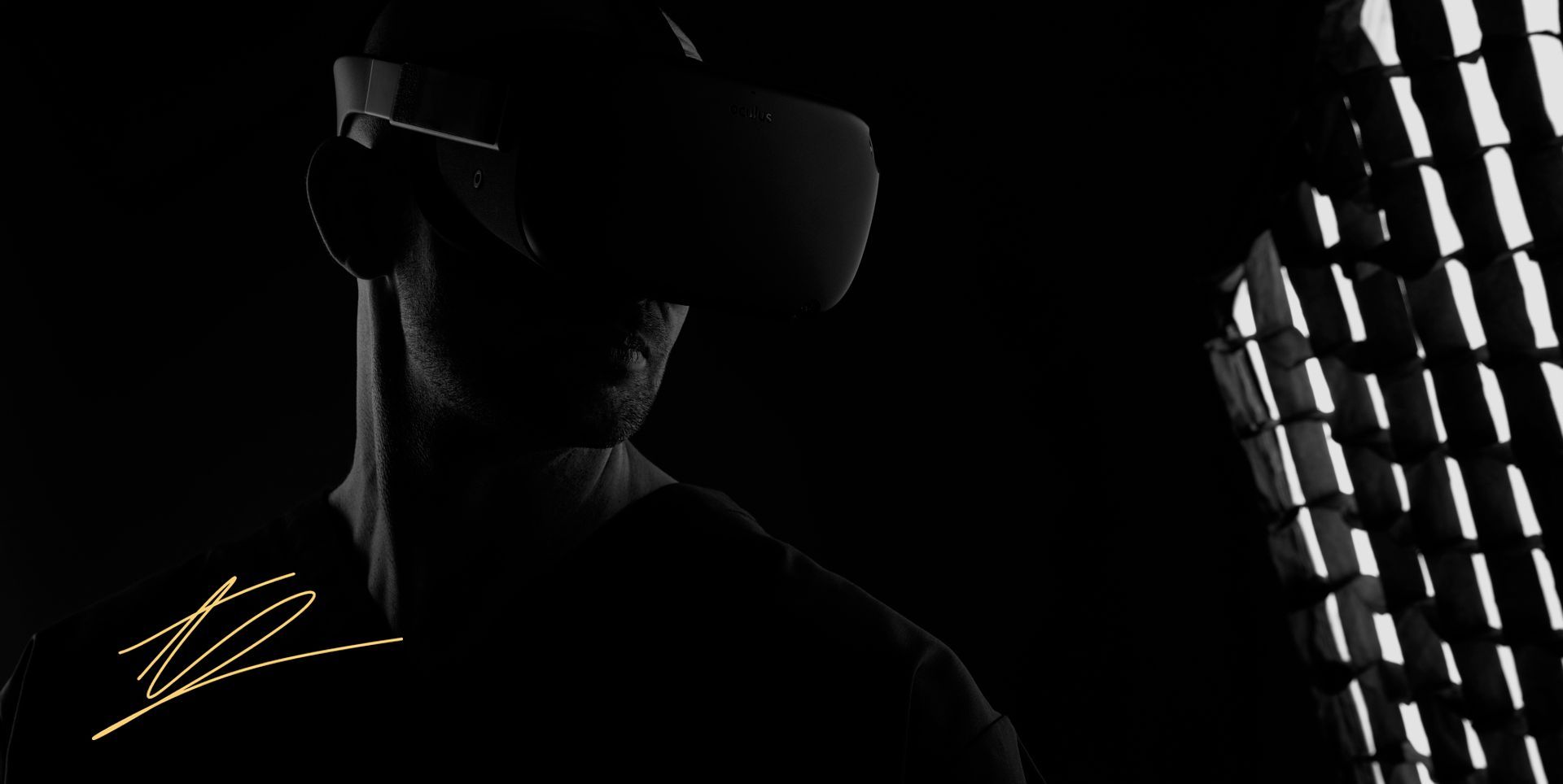 Alex Young wearing a virtual reality headset in a dark studio photograph