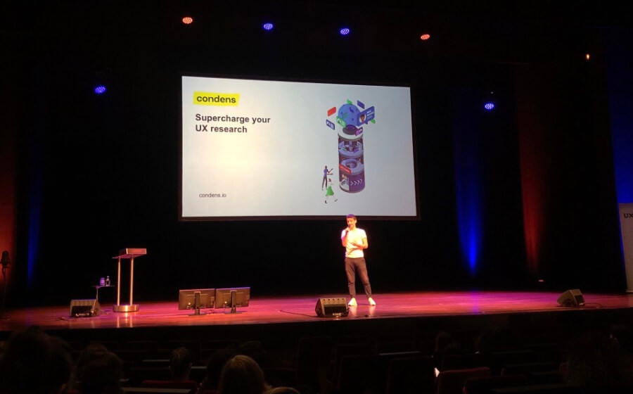 Alexander Knoll speaking to an audience with a presentation screen behind him