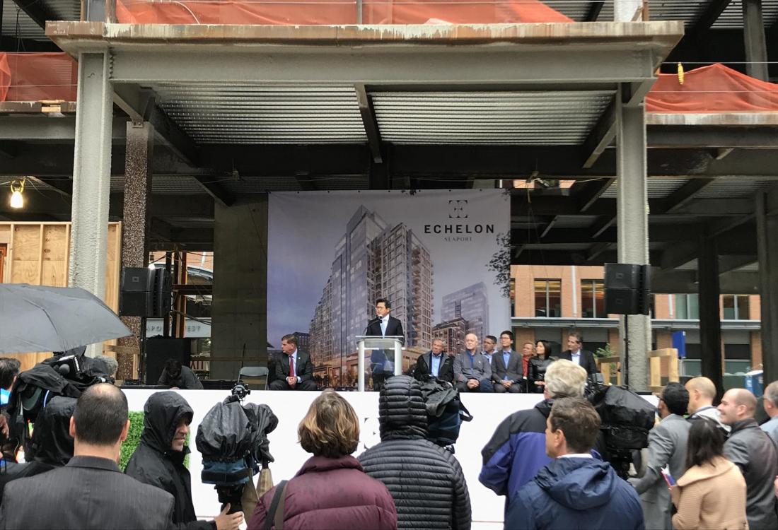 Alexander Shing at a lectern beneath exposed steel at EchelonSeaport’s topping-off ceremony