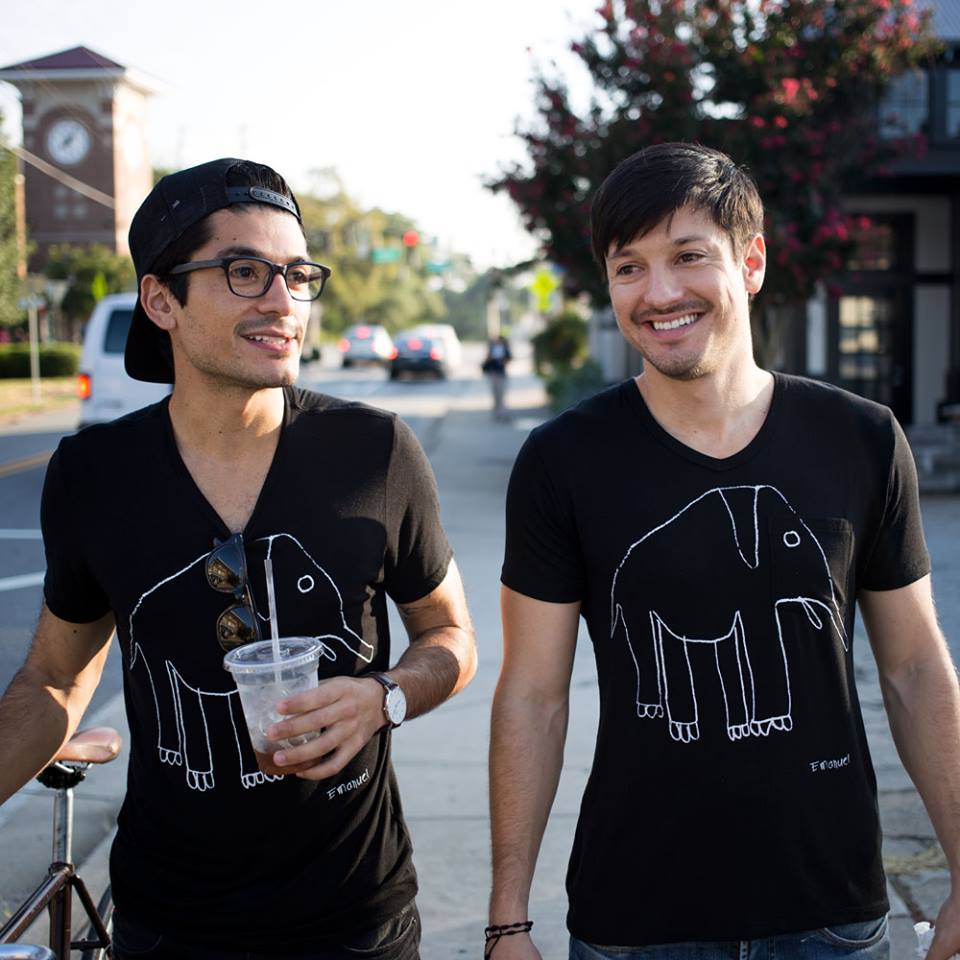 Alex and Jonathan Torrey wearing black umano shirts decorated with a child’s elephant drawing