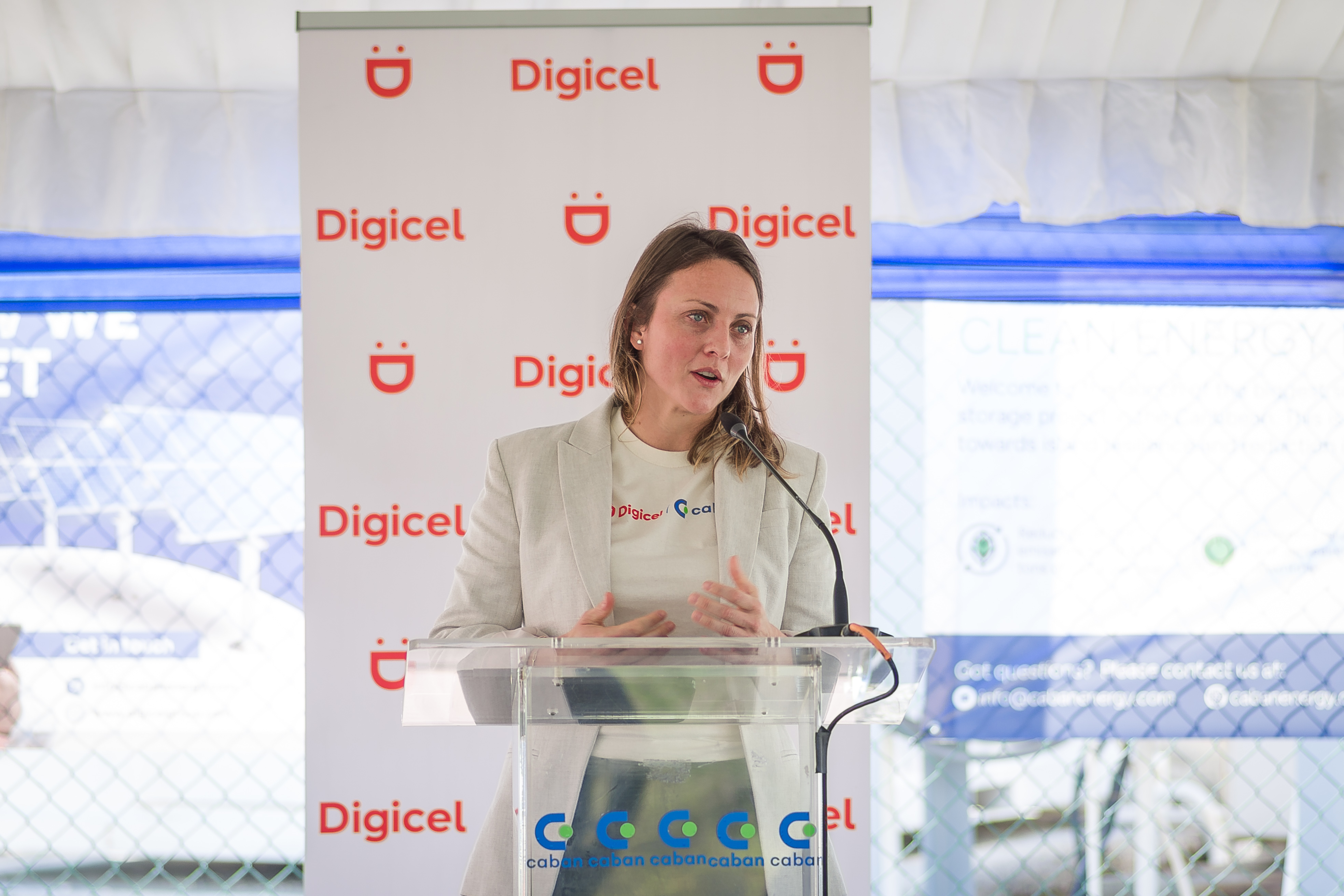 Alexandra Rasch Castillo speaking at a clear lectern during the Digicel and Caban launch in Jamaica