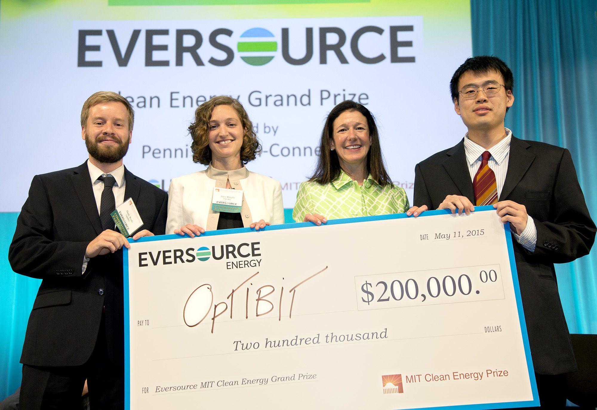 Mark Wade, Alexandra Wright-Gladstein, Penni McLean Conner and Chen Sun holding the OptiBit prize check at MIT in 2015.