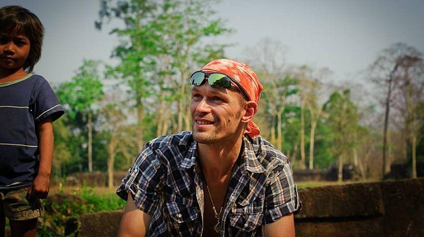 Alexey Abolmasov outdoors, wearing a red bandanna and sunglasses above his forehead