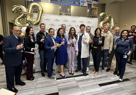 Alexis Mussi and colleagues gathered with local officials beneath gold twentieth-anniversary balloons at Southern Hills Hospital