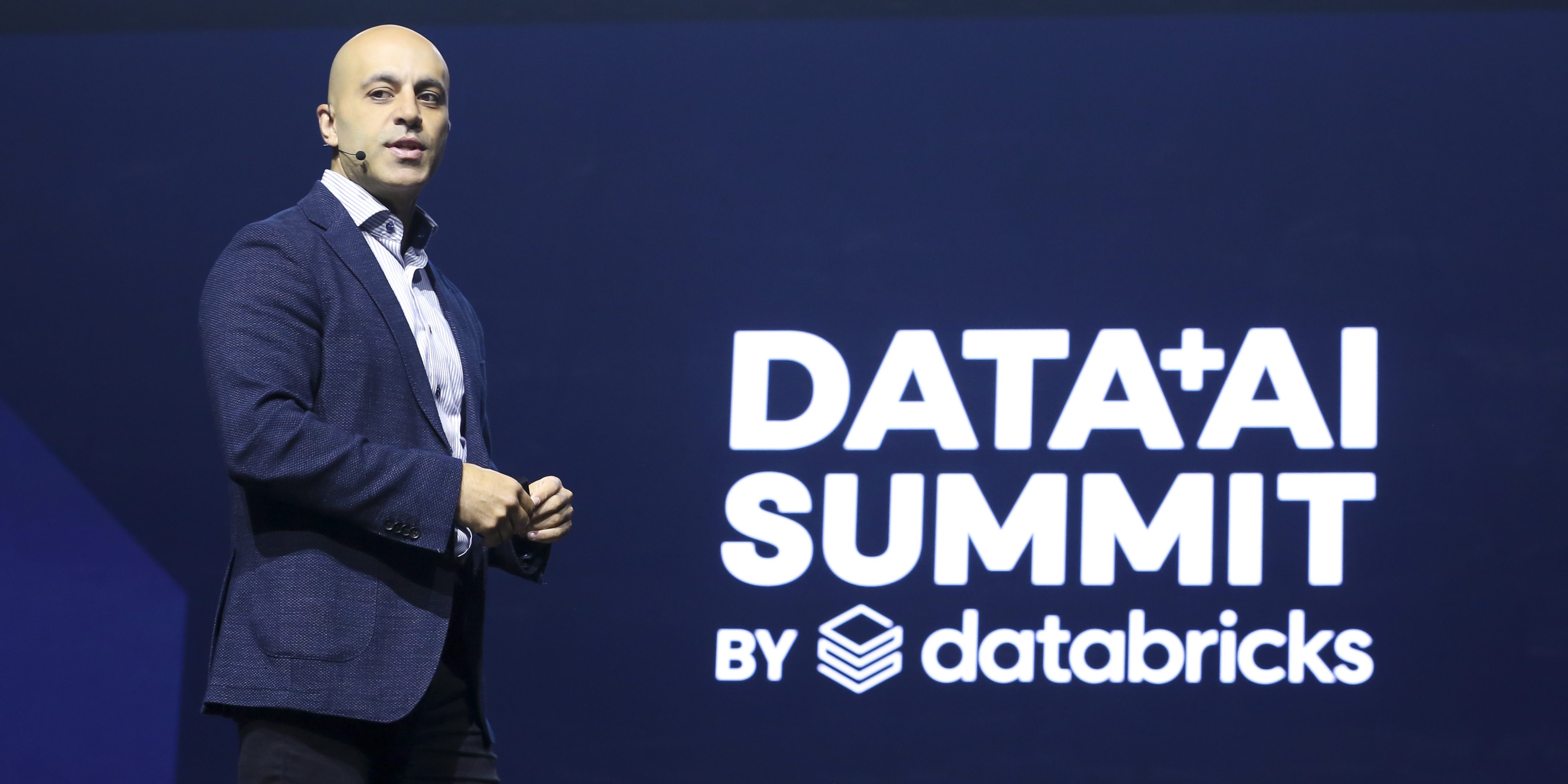 Ali Ghodsi speaking onstage at the Data and AI Summit