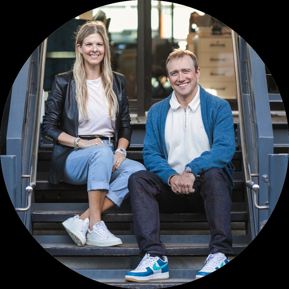 Alicia Roach and Chris Hare sitting on steps, both wearing sneakers