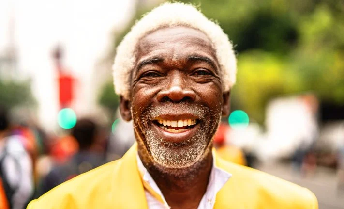 An older man in a yellow jacket smiles in Alignment Health’s campaign photography