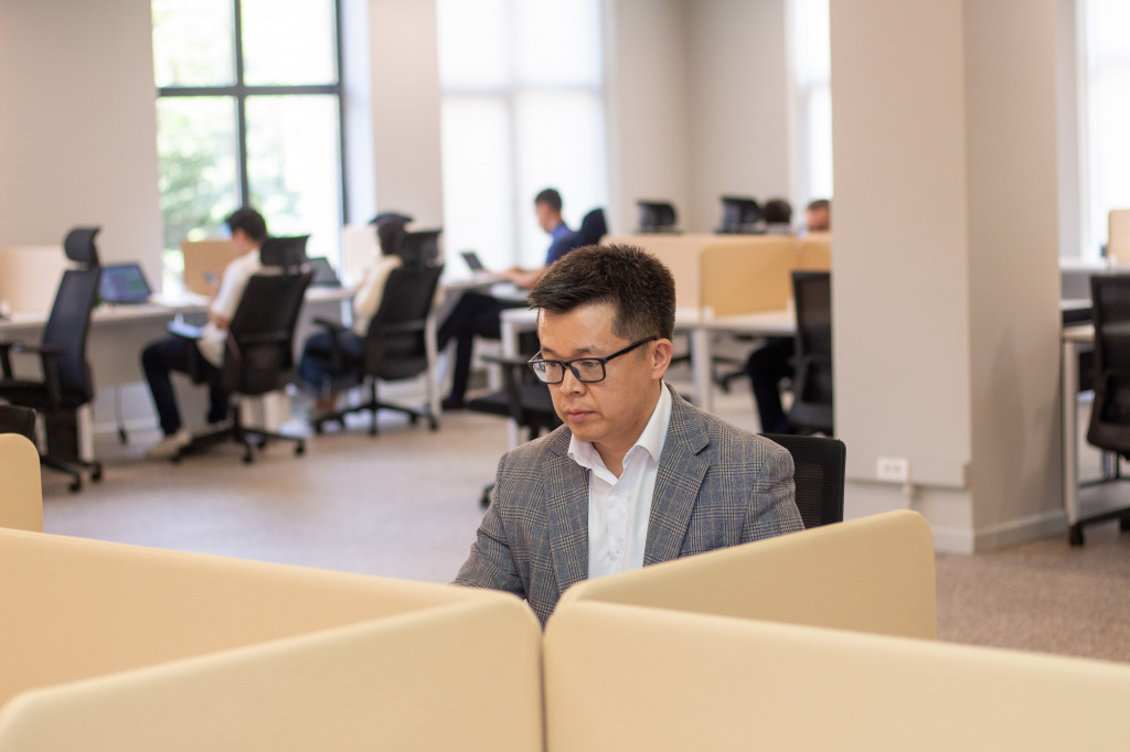 Alim Khamitov working at a desk in a shared MOST office