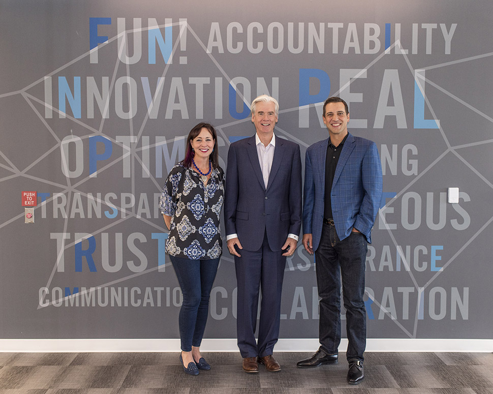 Alkami leaders standing inside the preserved bank vault at the company's Plano office